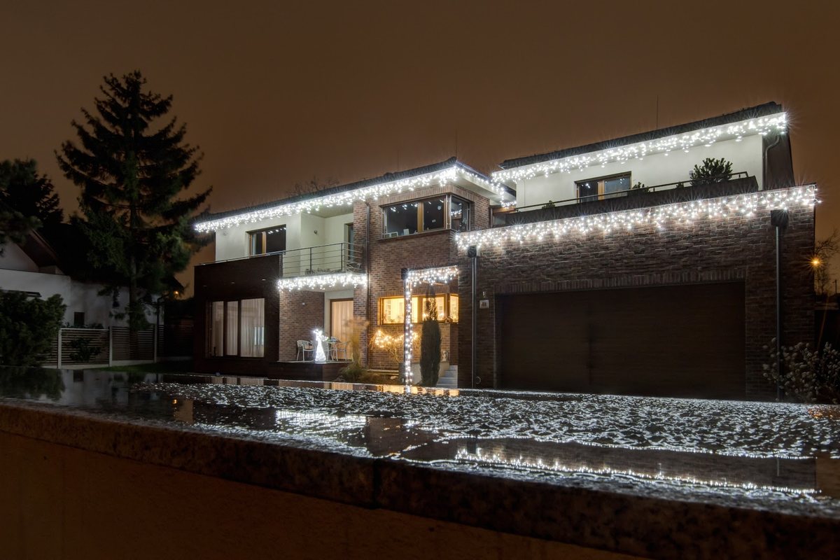 Modernes Wohnhaus bei Nacht mit LED-Lichterkette an den Dachkanten